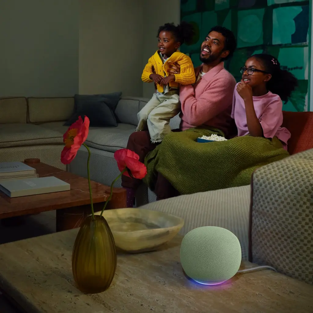 عائلة في غرفة المعيشة مع سماعة Google Home Speaker