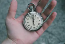 ساعة إيقاف في كف يد، رمز لقياس الأداء