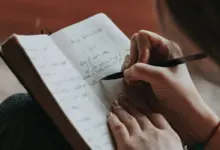 امرأة تكتب ملاحظات في دفتر أثناء تعلم مهارة جديدة
