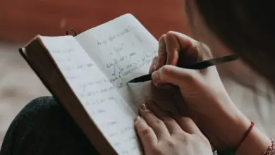 امرأة تكتب ملاحظات في دفتر أثناء تعلم مهارة جديدة