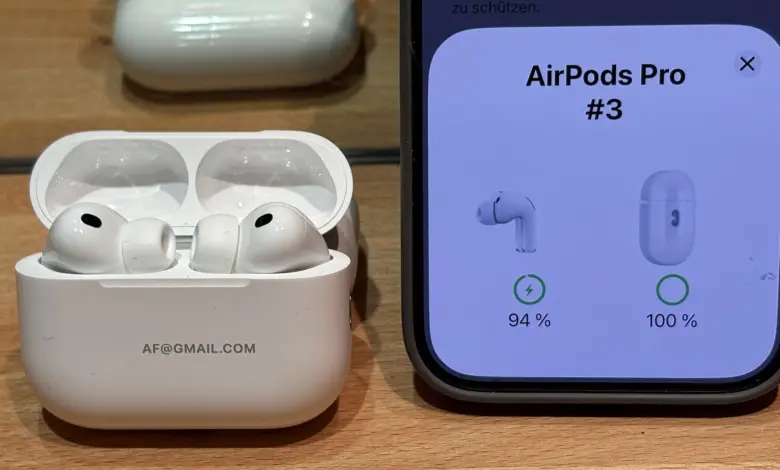 AirPods Pro 3 داخل علبة الشحن وبجانبها شاشة آيفون تعرض نسبة شحن كل جانب
