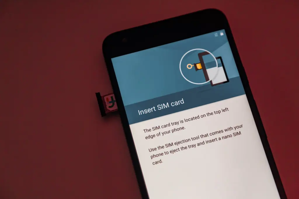 هاتف أندرويد تظهر على شاشته تعليمات إدخال شريحة SIM وبجانبه درج الشريحة
