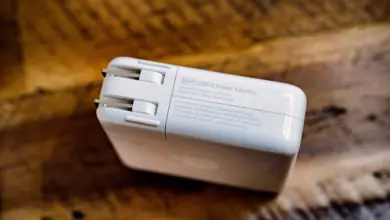 محوّل طاقة USB-C أبيض بقدرة 96 واط على سطح خشبي