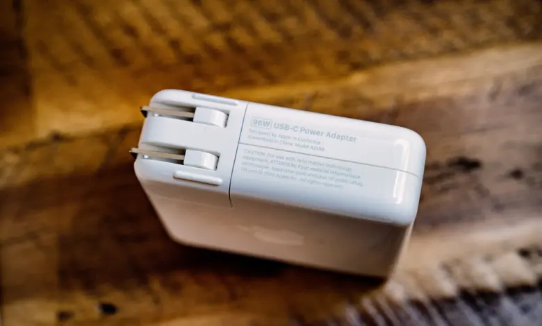 محوّل طاقة USB-C أبيض بقدرة 96 واط على سطح خشبي