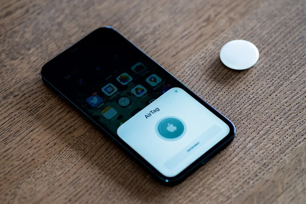 آيفون يعرض شاشة إعداد AirTag بجوار المتتبع