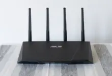 راوتر واي فاي من ASUS بأربعة هوائيات على طاولة