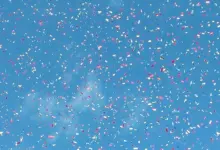 قصاصات ملوّنة تتناثر على خلفية سماء زرقاء