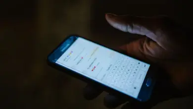يد تمسك هاتفًا في الظلام تظهر على شاشته لوحة مفاتيح ورسالة