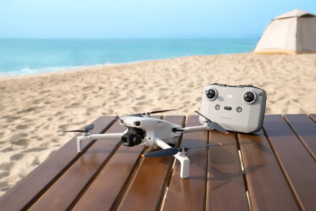 طائرة DJI Lito 1 إلى جانب جهاز التحكم RC-N3 على طاولة خشبية
