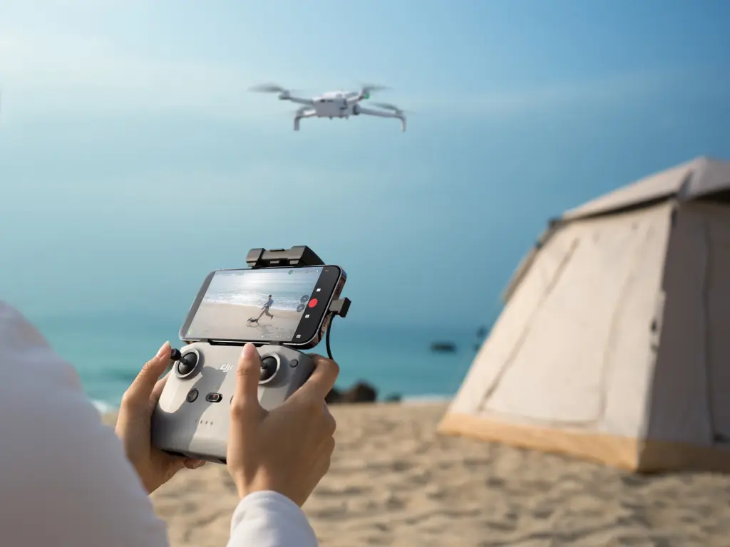 مستخدم يمسك جهاز تحكم DJI والهاتف أثناء قيادة Lito 1