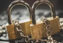 قفلان ذهبيان بسلسلة فوق لوحة مفاتيح كناية عن حماية الحسابات