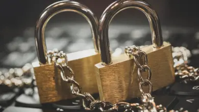 قفلان ذهبيان بسلسلة فوق لوحة مفاتيح كناية عن حماية الحسابات