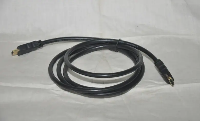 كابل HDMI أسود ملفوف على قماش أبيض