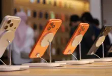 آيفون 17 برتقالي على حامل عرض في متجر