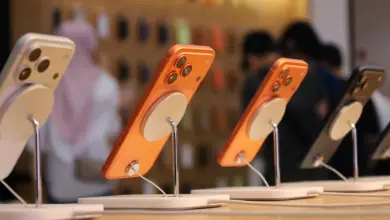 آيفون 17 برتقالي على حامل عرض في متجر