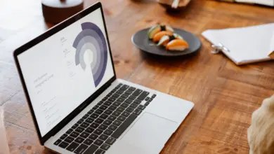 حاسوب محمول يعرض مخططًا دائريًا على مكتب خشبي