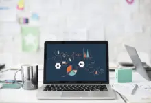 لابتوب تعرض شاشته مخططات بيانية على مكتب