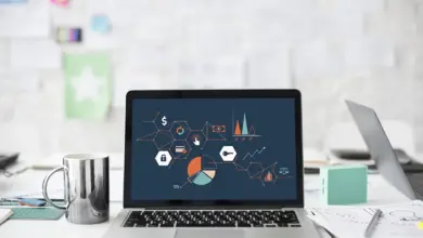 لابتوب تعرض شاشته مخططات بيانية على مكتب