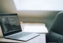 حاسوب محمول يعرض محرر أكواد على مكتب