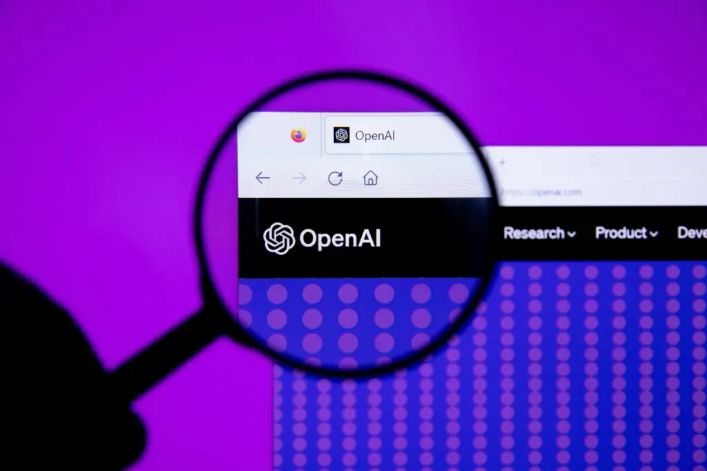عدسة مكبّرة تكبّر شعار OpenAI على شاشة موقعها