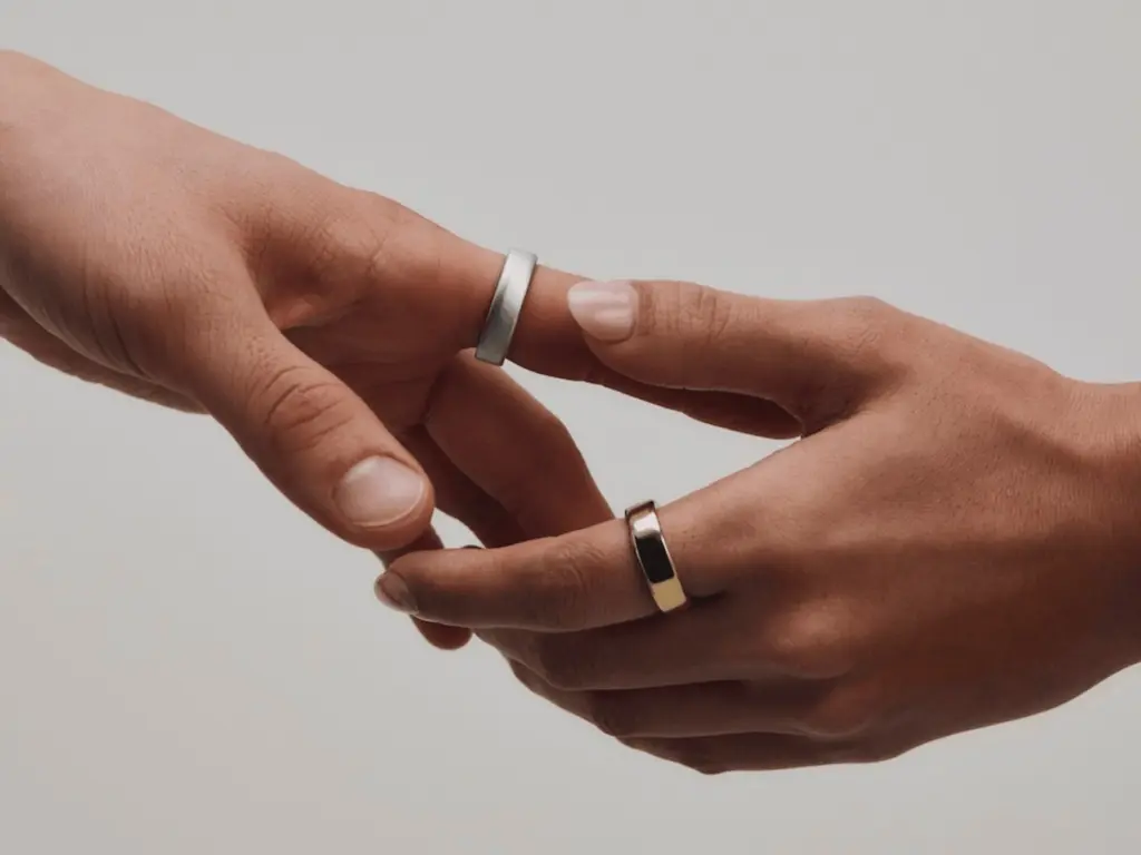 يدان ترتديان خاتم Oura Ring 5 الأصغر حجمًا بين الأصابع