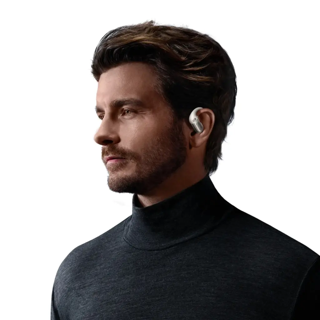رجل يرتدي سماعة Shokz OpenFit Pro البيضاء في أذنه