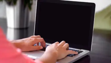 يدان على لوحة مفاتيح لابتوب أثناء الكتابة