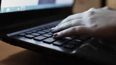 يد على لوحة مفاتيح لابتوب أسود